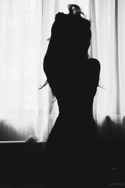 Mulher refletindo diante do espelho, representando o processo de despertar da feminilidade e autoconhecimento.